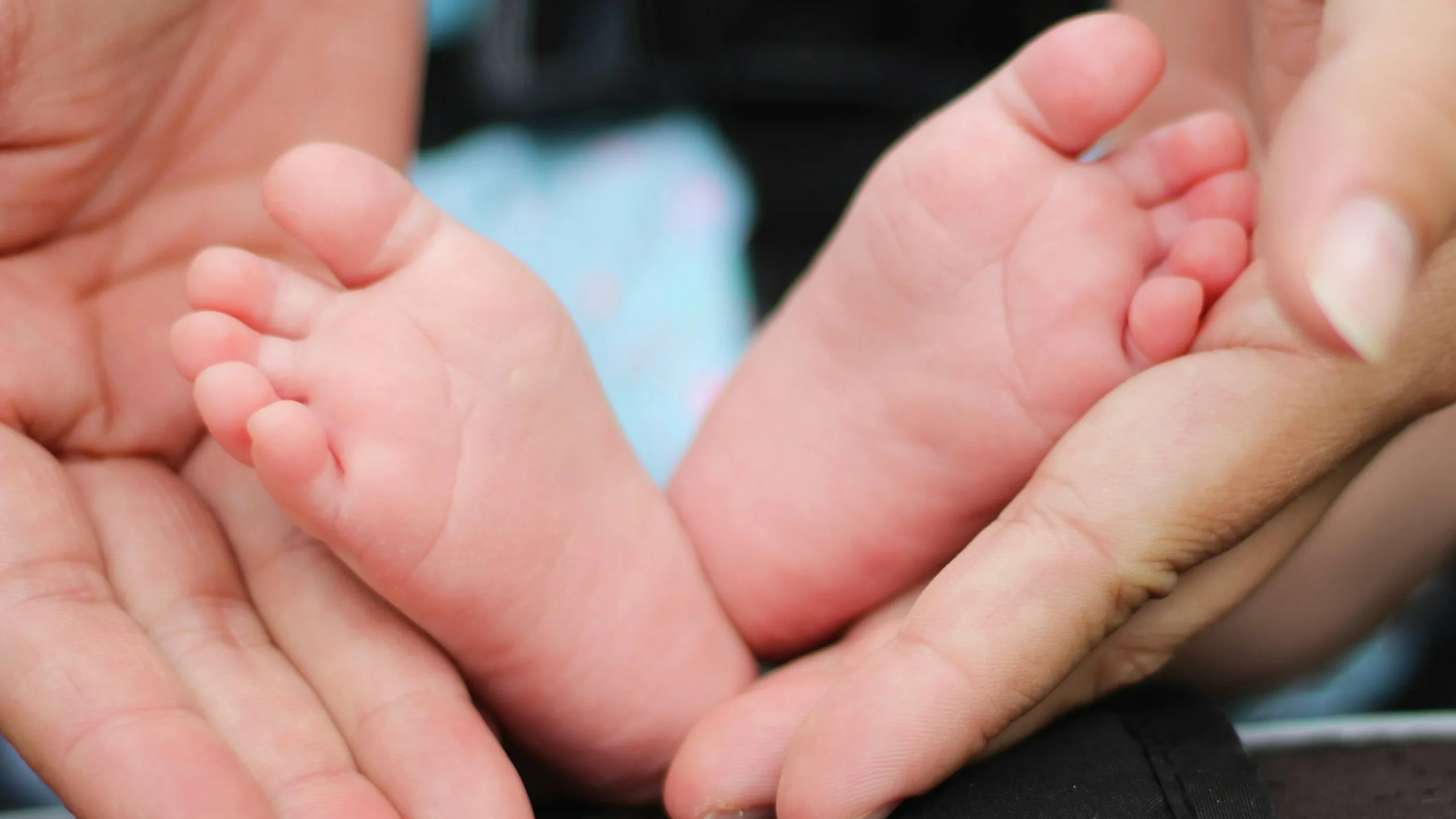 Babyfüße, sanft in zwei Händen gehalten