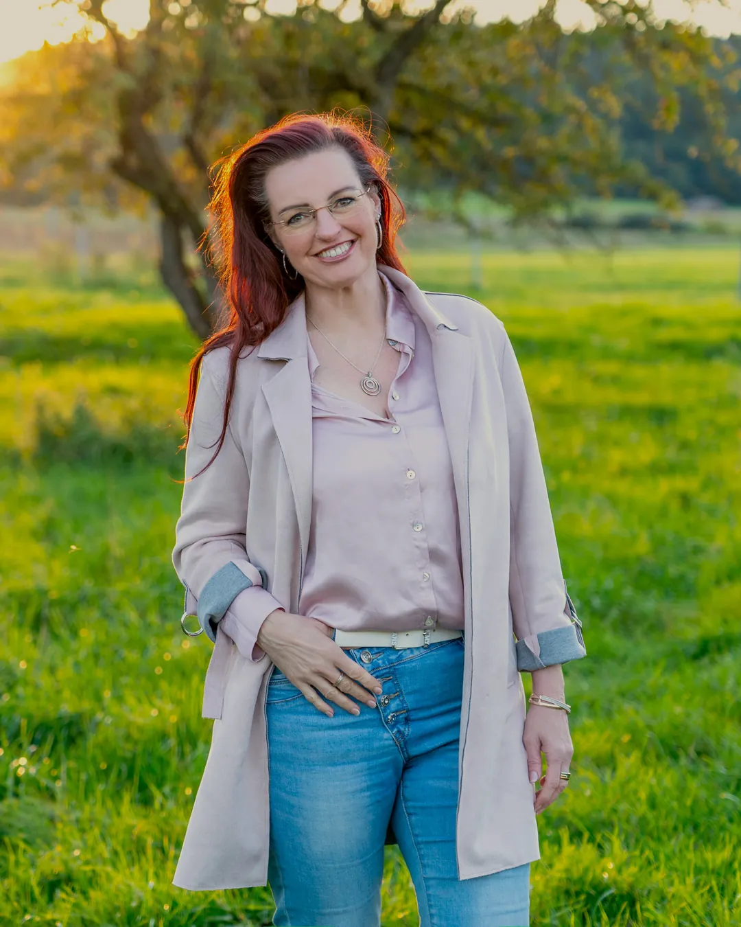 Stefanie Weber lächelnd auf einer Wiese im Abendlicht
